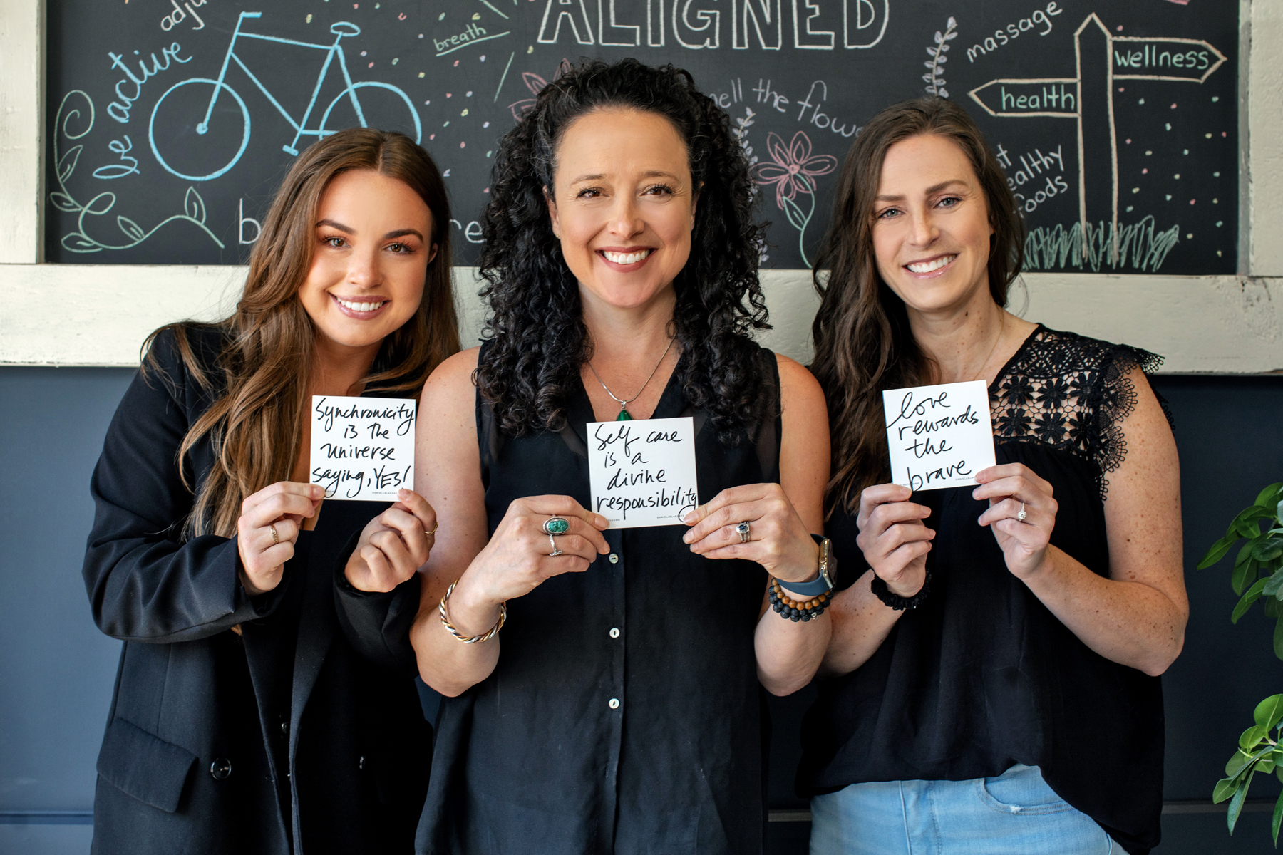 Female practitioners smile and hold motivational notes