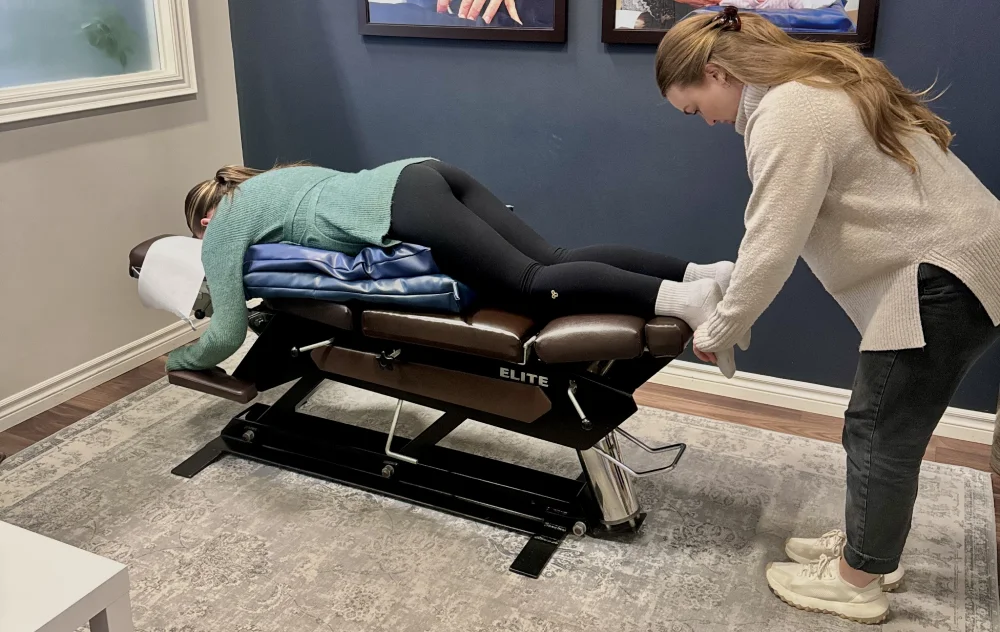 Female chiropractor performs assessment on pregnant woman