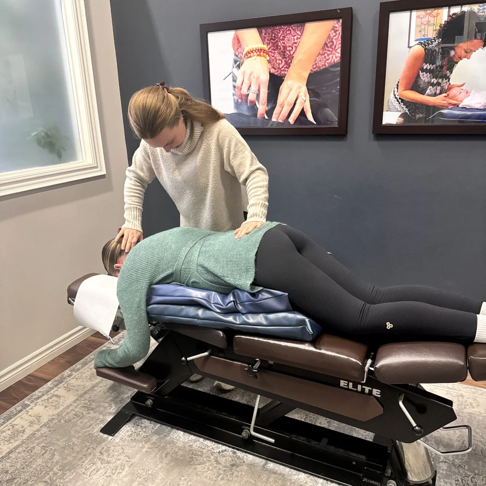 Female chiropractor administers treatment to pregnant woman